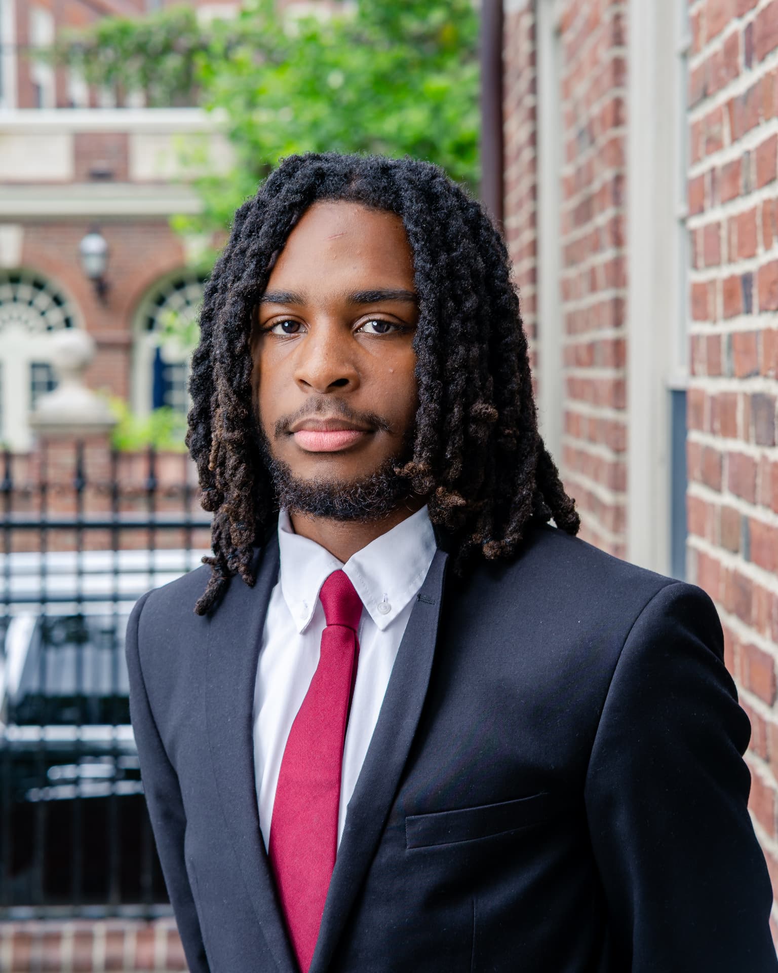 Portrait of Ashton Brandon in a dark suit and red tie
